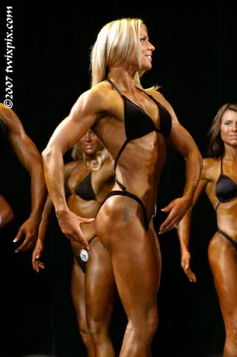 Fawnia posing on stage in a competition bikini at a fitness competition (photo 9)