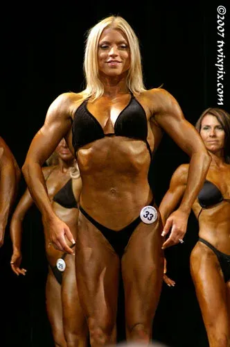 Fawnia posing on stage in a competition bikini at a fitness competition (photo 10)