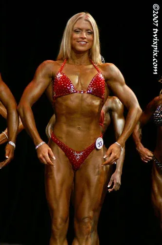 Fawnia posing on stage in a competition bikini at a fitness competition (photo 13)