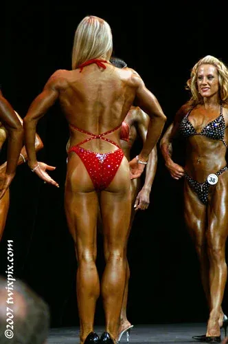 Fawnia posing on stage in a competition bikini at a fitness competition (photo 14)