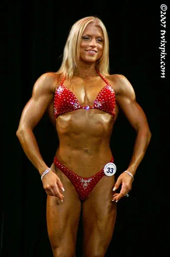 Fawnia posing on stage in a competition bikini at a fitness competition (photo 17)